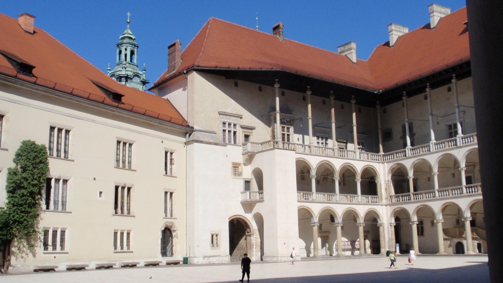 Wawel courtyard. The location of the chakra stone is believed to be below floor under the wall behind the intersection of the two colonnaded porticos.